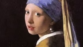 En ung kvinde med et blåt og gult tørklæde og en perleørering kigger sig over skulderen mod en mørk baggrund, inspireret af det berømte maleri Girl with a Pearl Earring.