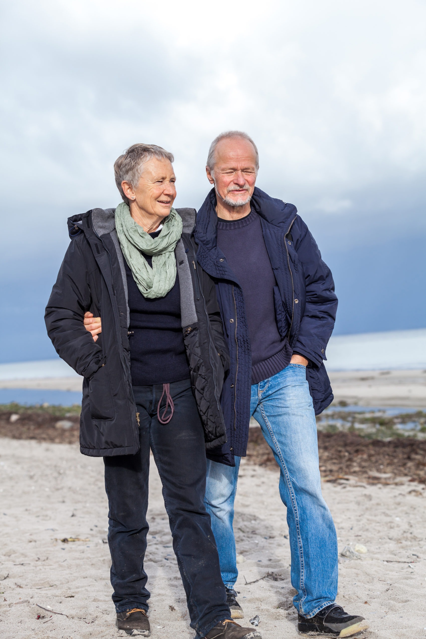 happy elderly senior couple walking on beach
