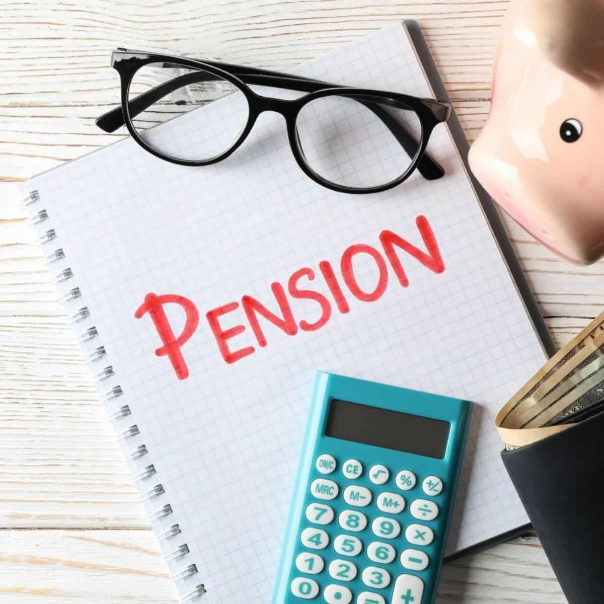 Pension planer og økonomi Pension, regnemaskine og briller på notesbog.