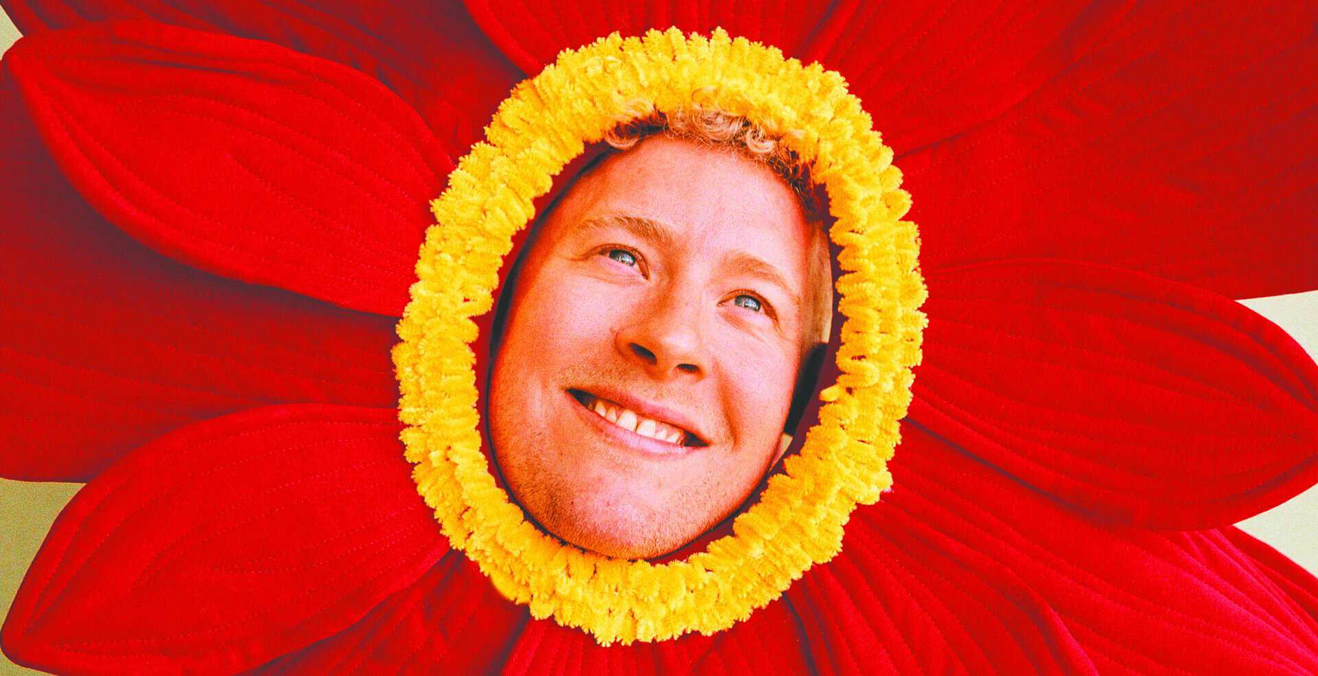 Menneske i blomsterkrans Mand med blomsterkrans i ansigtet, smilende og glad.