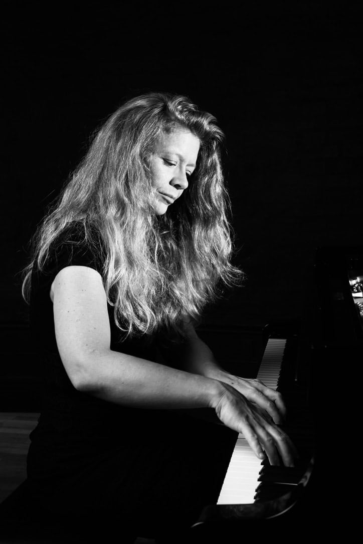 Kvindelig pianist spiller klaver i sort-hvid foto.