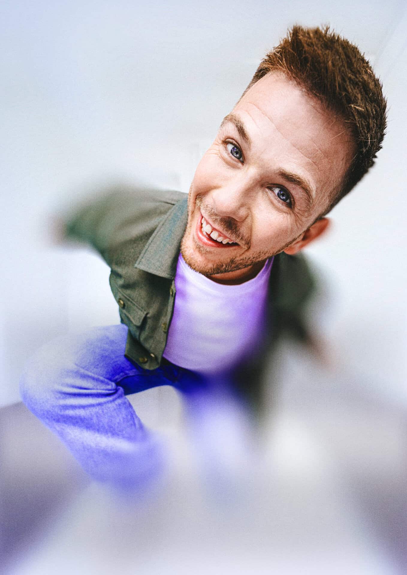 Ung mand med kort hår smiler og ser direkte i kameraet.