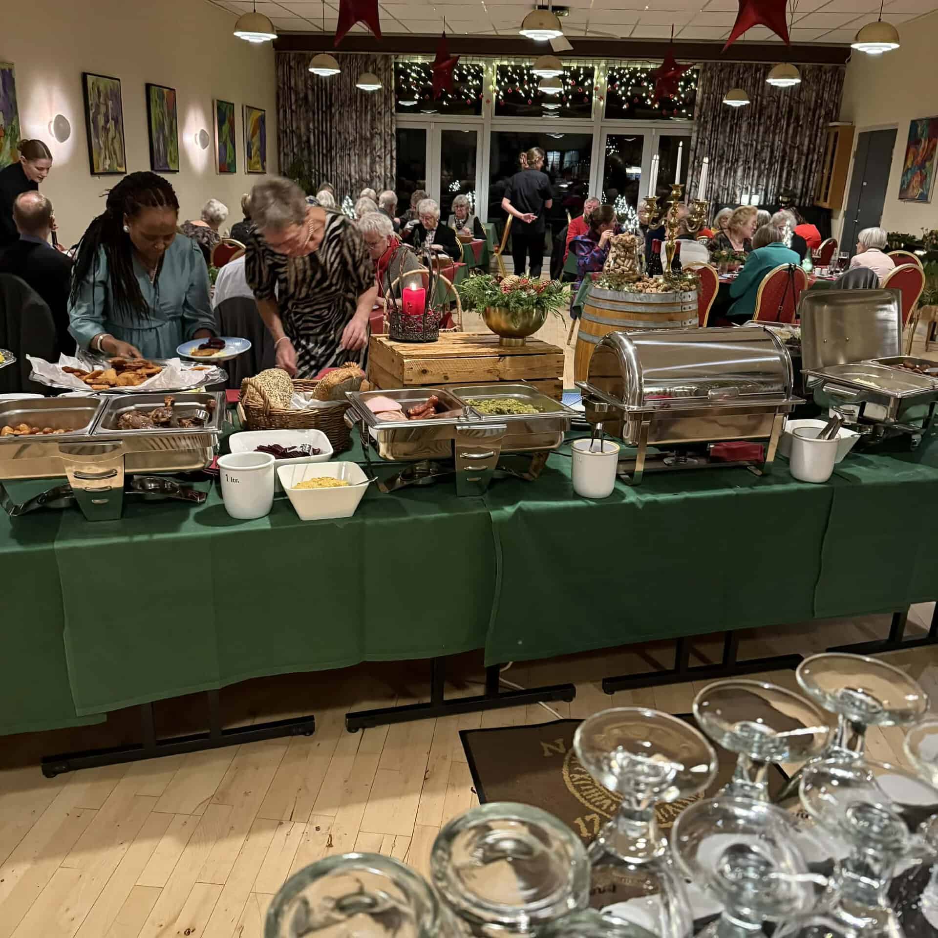 Julefrokostbuffet med mange gæster og julepynt i Sønderborg.